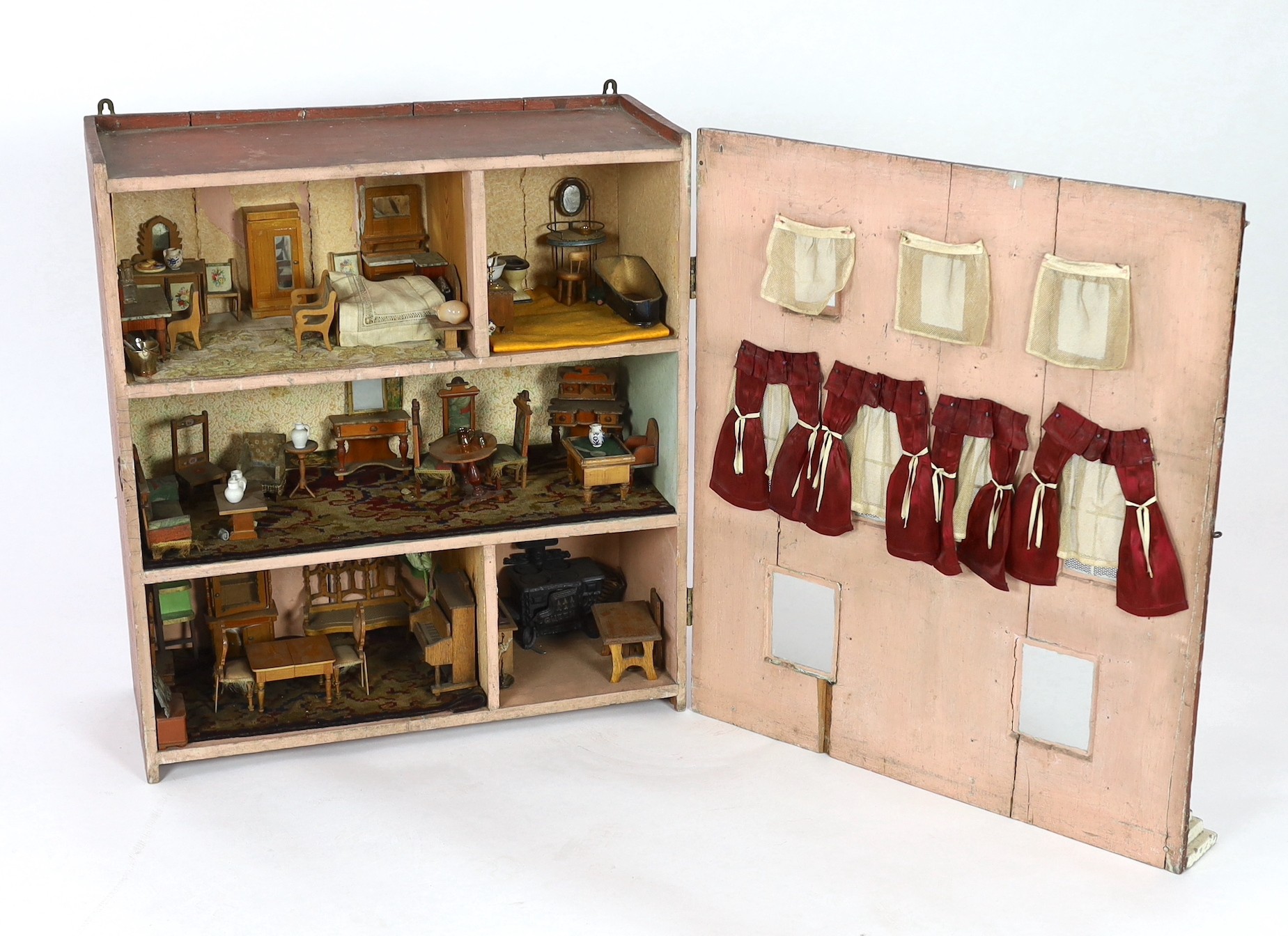 A Victorian furnished dolls’ house, circa 1890, 77cm high.